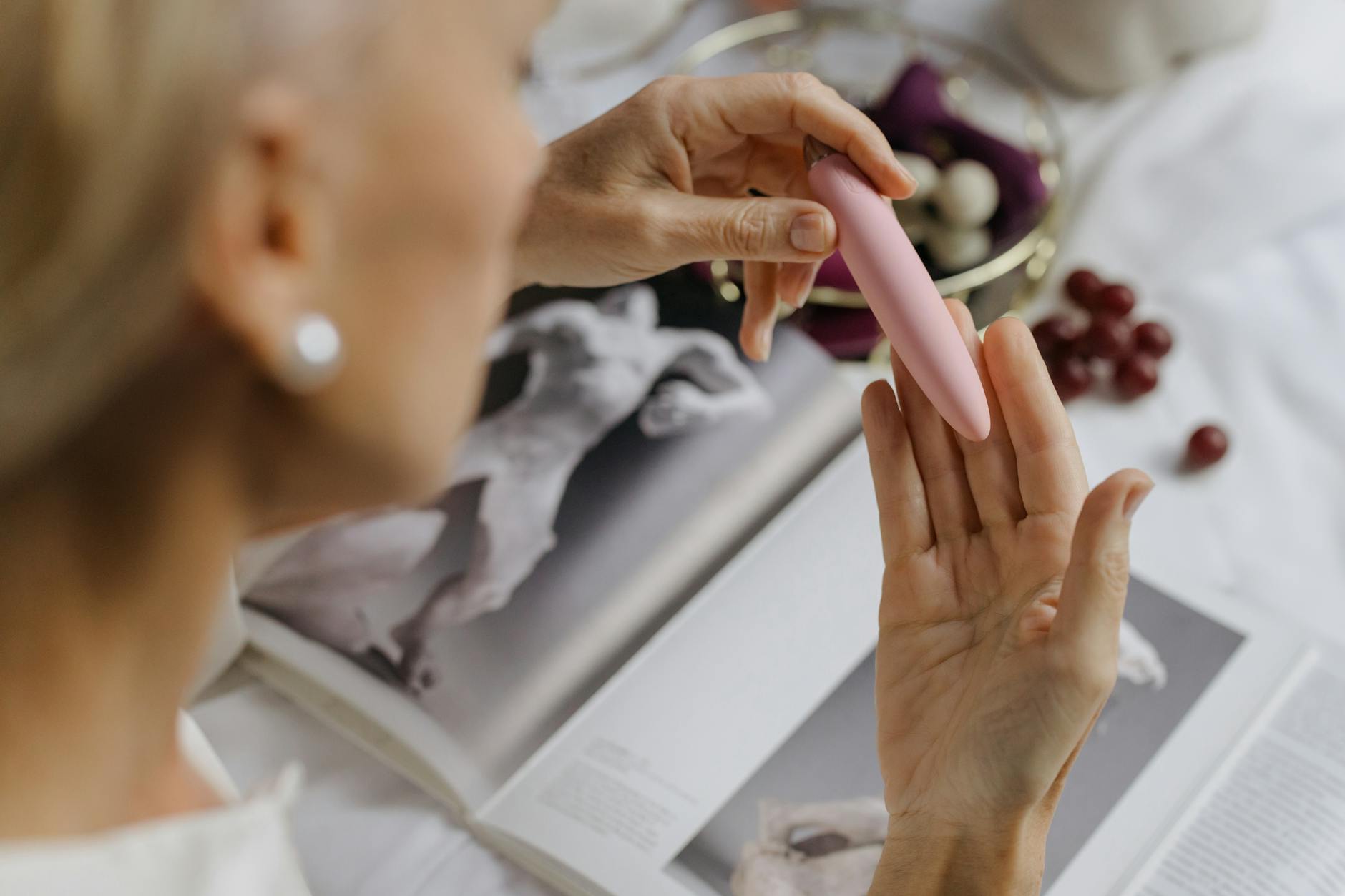 Vrouw met bril die blauwe en roze siliconen vibrators vasthoudend, contemplerend moment