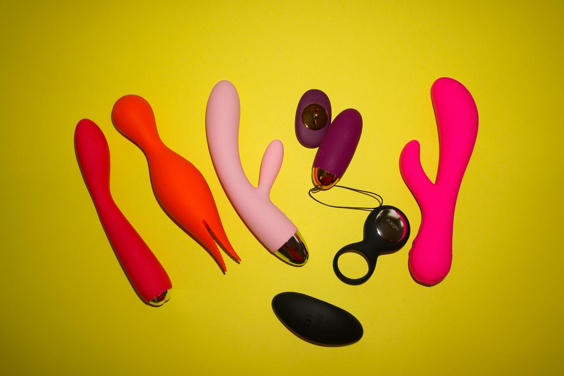 Vrouw met bril houdt twee gekleurde vibrators vast in contemplatieve houding